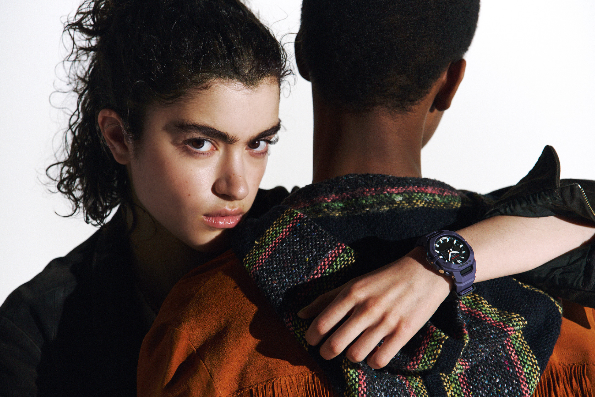 佩戴紫色 G-SHOCK 的人拥抱另一个人。