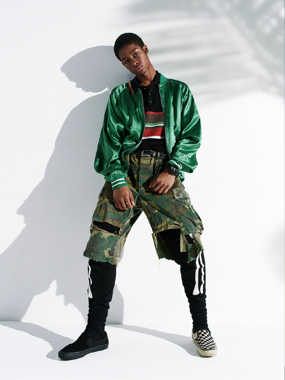 身穿绿色缎面夹克和迷彩裤，佩戴黑色 G-SHOCK 的人。