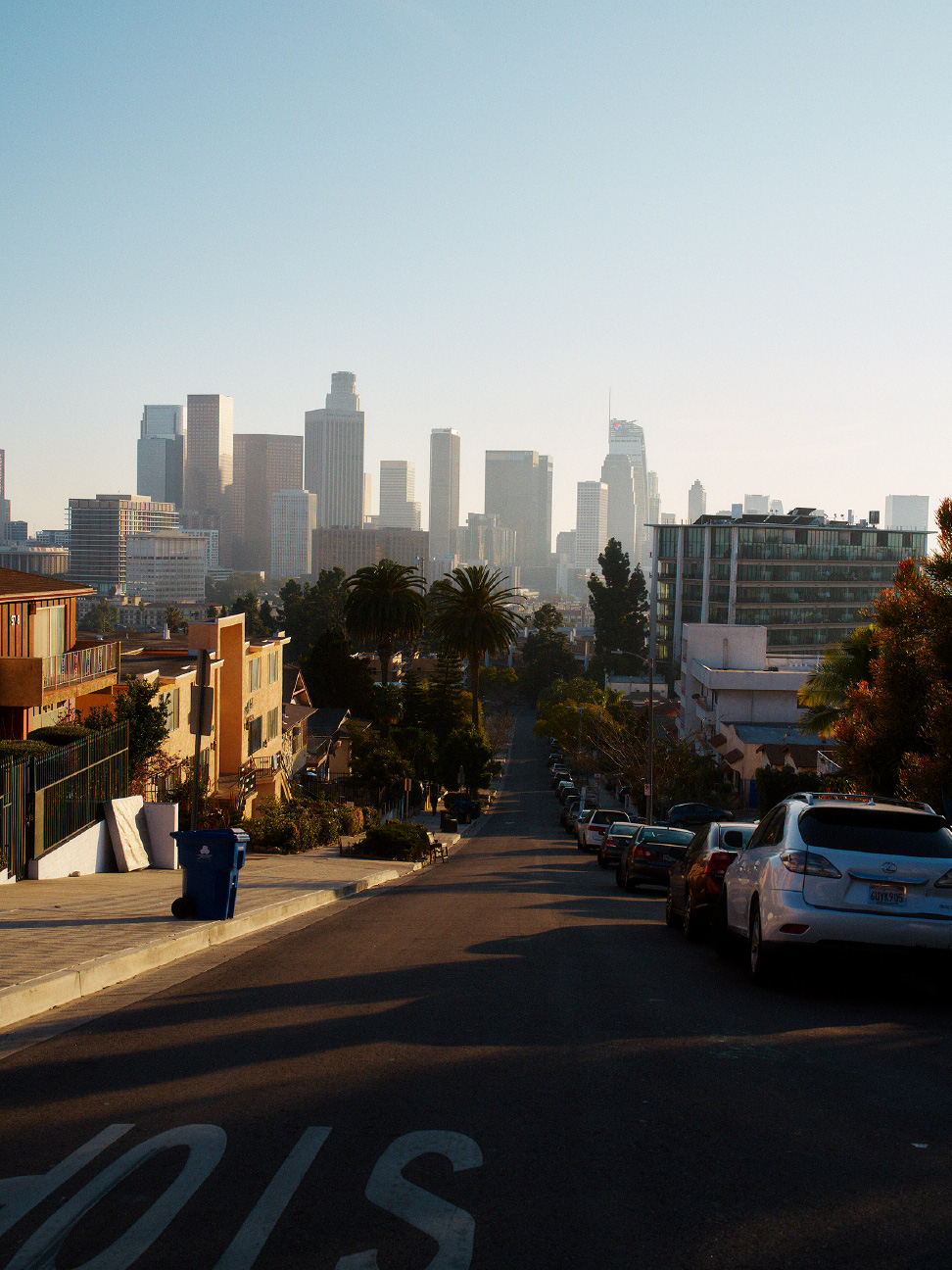 从倾斜的街道上俯瞰洛杉矶市中心的城市景观。