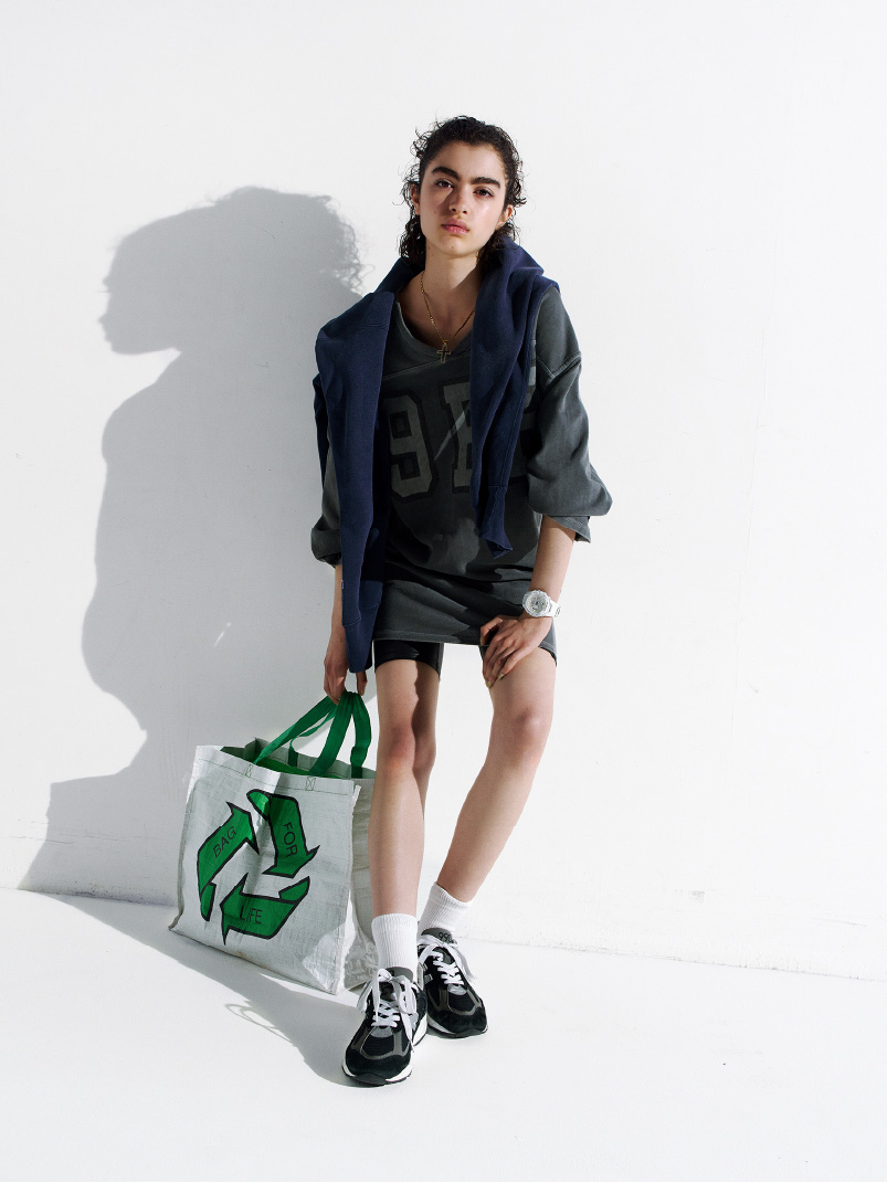 身着休闲装，手持以回收为主题的袋子，佩戴白色 G-SHOCK 的人。