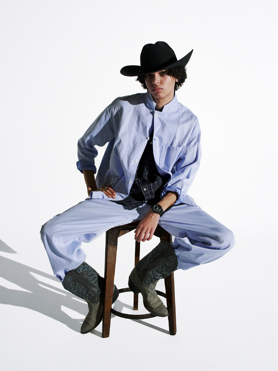 佩戴黑色 G-SHOCK 的人，戴着牛仔帽，穿着牛仔靴。