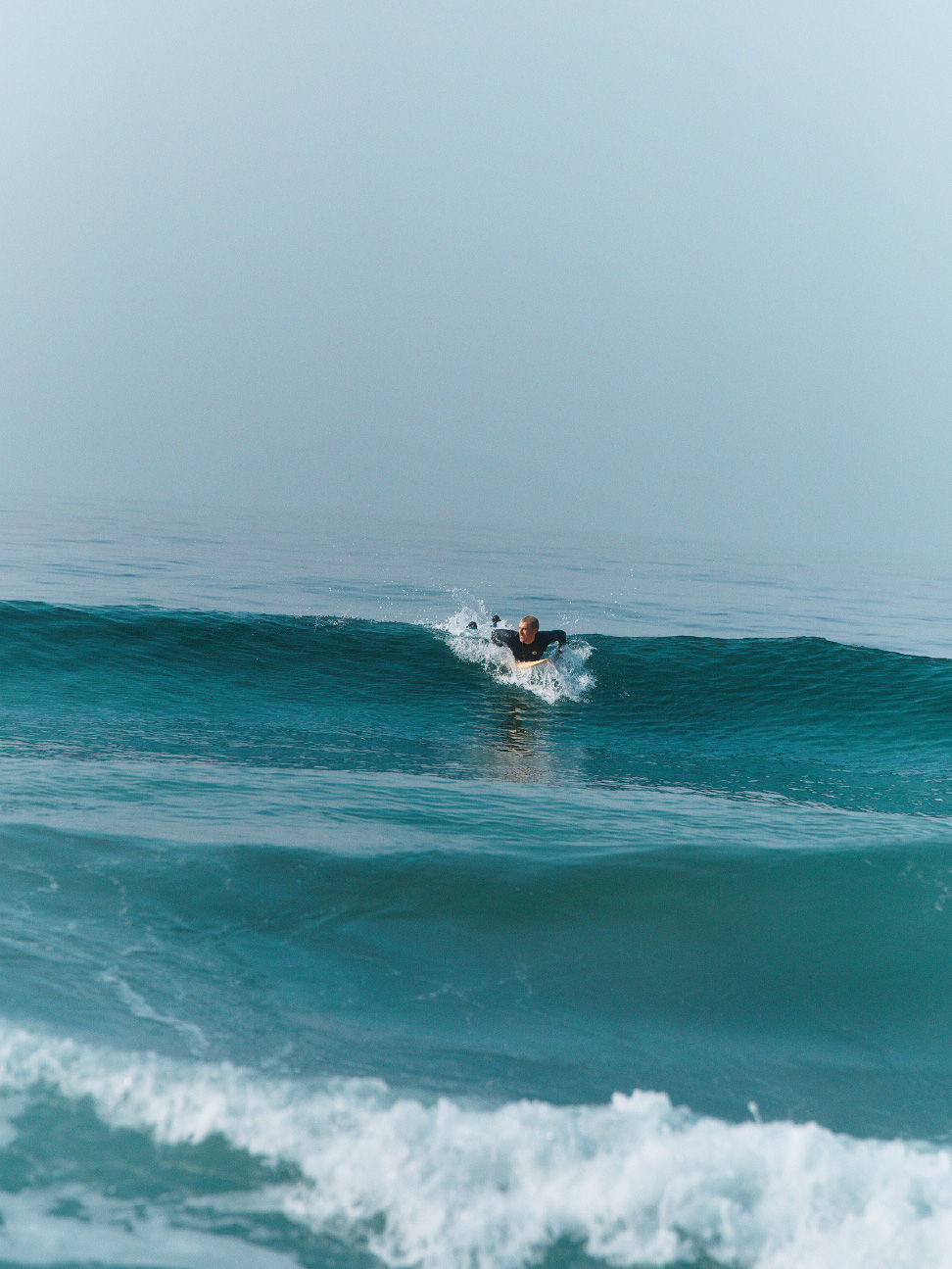 冲浪者划向海浪